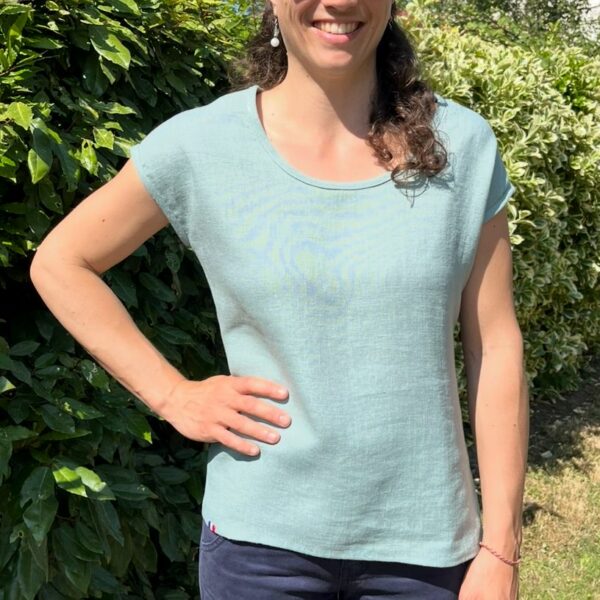 T-shirt de couleur vert céladon, presque vert d'eau porté sur une femme brune.