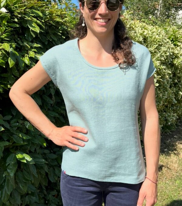 T-shirt de couleur vert céladon, presque vert d'eau porté sur une femme brune.