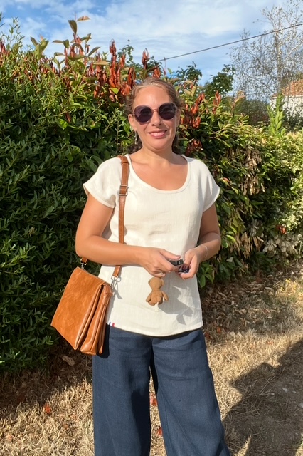 t-shirt crème et pantalon new bleu portés par une femme